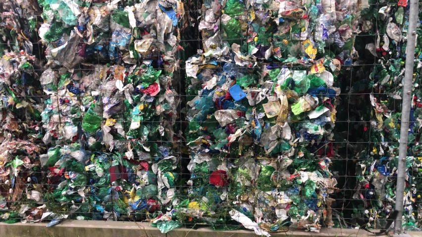 Pan Up View of Pressed Cubes Of Plastic Bottles Stacked Outside In Recycling Plant | Shutterstock HD Video #1060470181