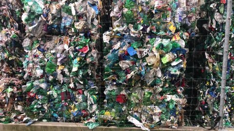 Pan Up View of Pressed Cubes Of Plastic Bottles Stacked Outside In Recycling Plant