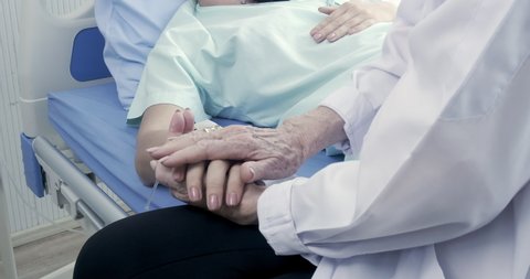 Close up holding hand of doctor comfort patient after tell bad new about injury symptom is cancer.
