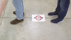 COVID-19 coronavirus. Supermarket message asking customer to keep distance. Video of feet standing in public space practicing social distancing. - Powered by Shutterstock - Get 15% off with code: PIKWIZARD15
