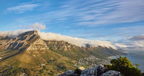 4k right to left panning time elapse of rolling clouds over table top mountain at sunset and the city of Cape Town,South Africa
