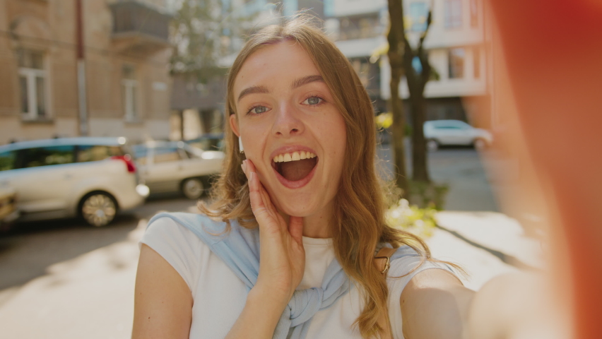 Happy attractive young woman posing to camera make selfie smiling at sunlight on street. Outdoors. Close up chat cellphone call. Slow motion | Shutterstock HD Video #1060474033