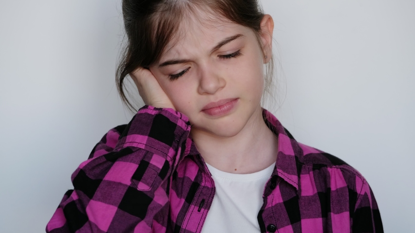 little / young sad girl holding a sore ear. Otitis. Royalty-Free Stock Footage #1060474897
