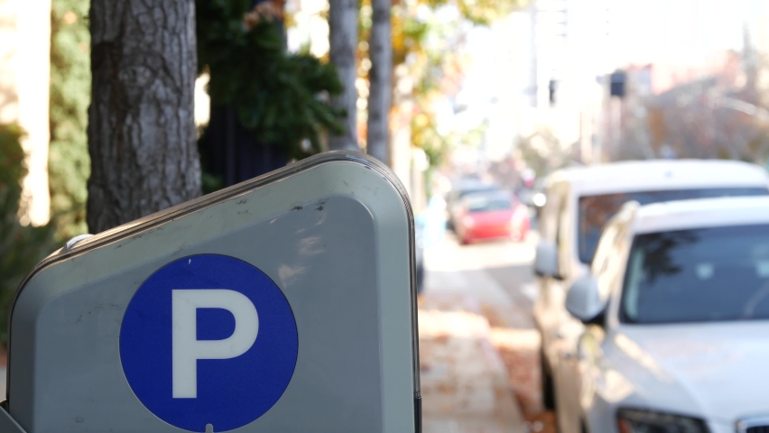 Parking lot sign as symbol of traffic difficulties and transportation issues in busy urban areas of USA. Public paid parking zone in downtown of San Diego, California. Limited space for cars in city.
