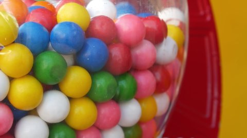 Colorful gumballs in classic vending machine, USA. Multi colored buble gums, coin operated retro dispenser. Chewing gum candies as symbol of childhood and summertime. Mixed sweets in vintage automate.