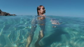 Woman in swimsuit swimming in the sea. Summer vibe. Slow motion video 4K