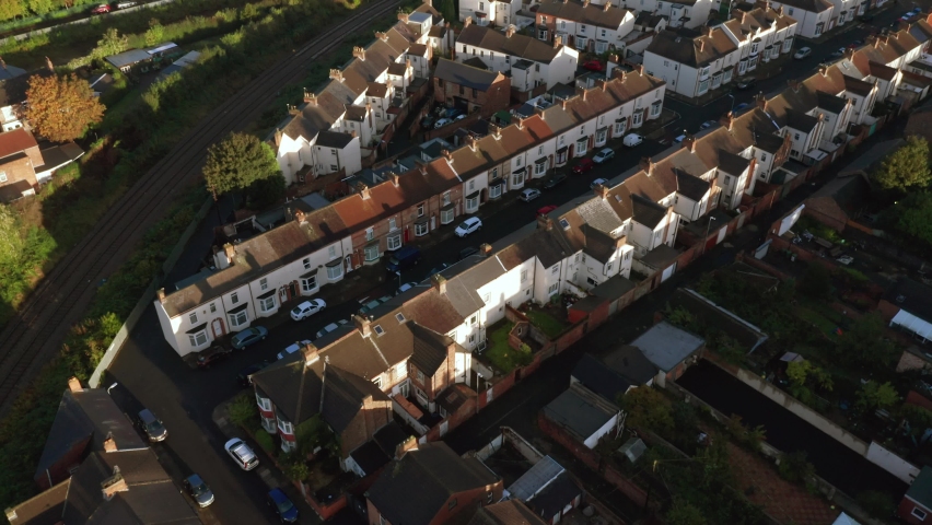 Aerial drone footage flying  overlooking housing estates, public parks and commercial properties in a built up area in the town of Stockton-on-Tees during an Autumn sunrise in England UK Royalty-Free Stock Footage #1060478023