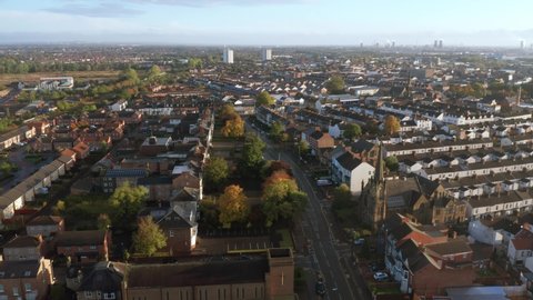 Aerial drone footage flying  overlooking housing estates, public parks and commercial properties in a built up area in the town of Stockton-on-Tees during an Autumn sunrise in England UK