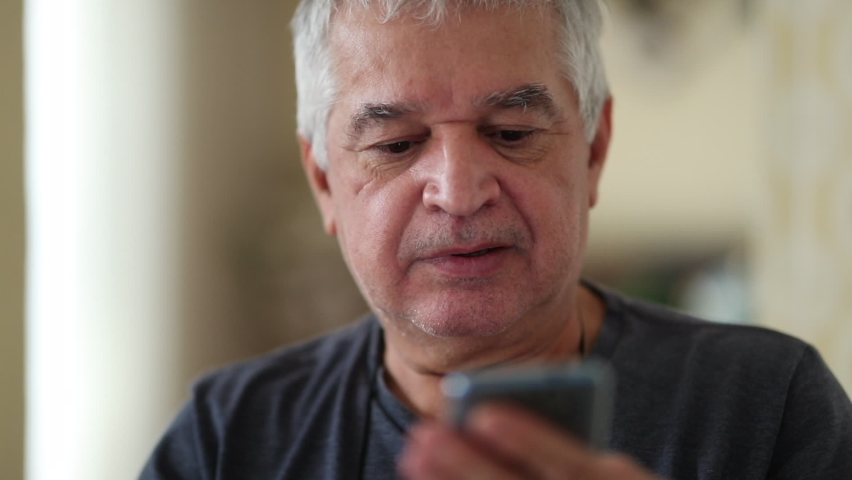 Casual elder man using cellphone device feeling satisfied | Shutterstock HD Video #1060478617