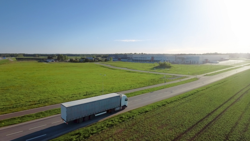 Advanced High-Tech Concept: Big Semi Truck with Cargo Trailer Drives on the Road is Transformed with Graphics Special Effects Into Digitalized Version of Futuristic Autonomous Truck. Aerial Drone Shot Royalty-Free Stock Footage #1060479187