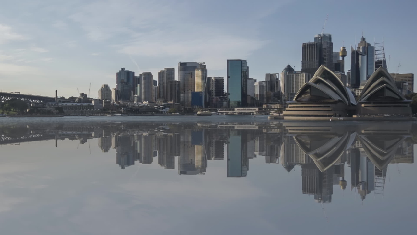 Time lapse of beautiful city skyline with water reflection effect, from sunset to sunrise (day to night to day). Pan right Royalty-Free Stock Footage #1060484947