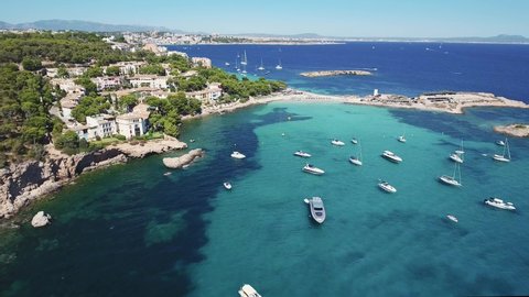 Beautiful aerial view of yachts and boats anchoring in a bay in Mallorca with clear turquoise water - Mediterranean Sea - Spain holiday - Beach in Majorca