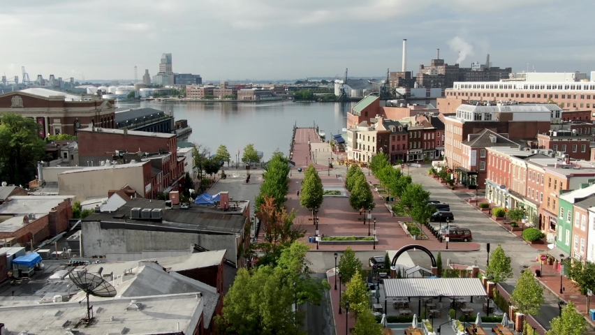 Aerial turn reveals Fells Point and Inner Harbor in Baltimore, colorful storefronts during morning magic hour, no people