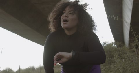 Body positive young black female model exercising outdoors looking at smart watch, Plus size overweight black woman sports training