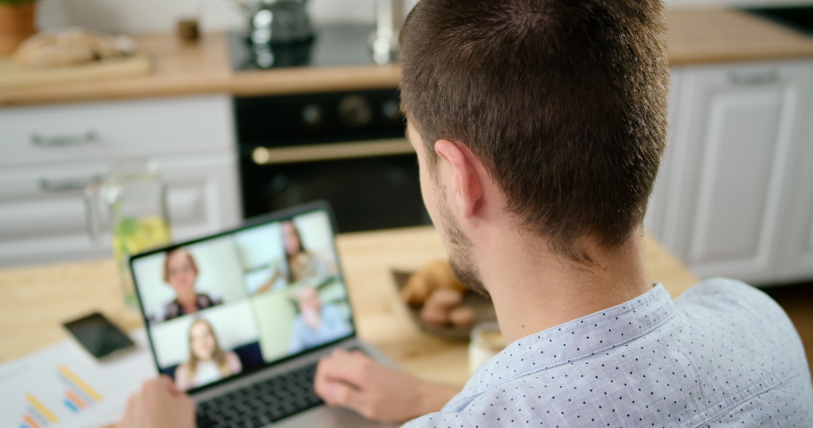 Online Group Video Call Conference of Work Team from Home Office. Man Talks with 4 People at Video Chat using Laptop in Kitchen. Self-isolation at COVID-19 Pandemic. 4K Top View Close-up Medium Shot Royalty-Free Stock Footage #1060495249