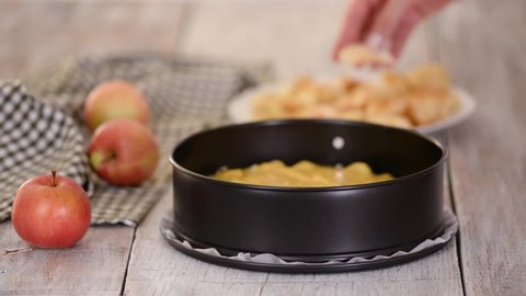 Baking Apple pie. Woman puts apple slices on a top of dough.