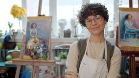 Slow motion portrait of pretty girl artist standing in art studio holding paintbrushes smiling looking at camera. Lifestyle, hobby and occupation concept. - Powered by Shutterstock - Get 15% off with code: PIKWIZARD15