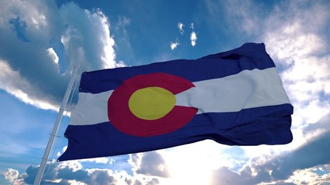 Colorado flag on a flagpole waving in the wind in the sky. State of Colorado in The United States of America