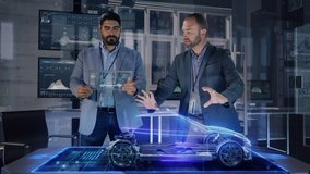 Professional Male Automotive Designers makes gestures and redesigns 3D Electric Concept Car Model using Holographic Table. High Tech Office use Virtual Augmented Reality Modeling Software Application. - Powered by Shutterstock - Get 15% off with code: PIKWIZARD15