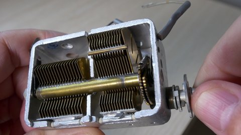 Double gang air variable capacitor with reduction gear. Variable capacity of an old tube radio. Dielectric, often used in radio tuning circuits
