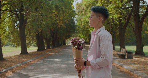 Lesbian giving flowers to girlfriend, romantic date in the park, same-sex couple วิดีโอสต็อก