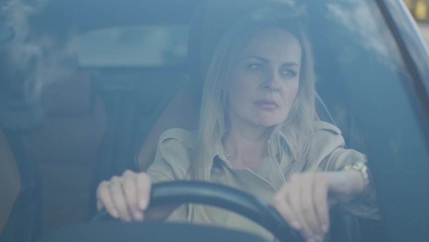 The stressed woman driver is sitting inside her car. Sad business woman is having headache has to make a stop after driving car in traffic jam on rush hour. Exhausted, overworked driver concept. Royalty-Free Stock Footage #1060529971