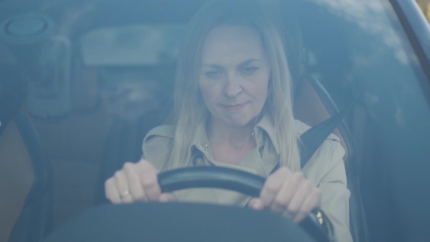 The stressed woman driver is sitting inside her car. Sad business woman is having headache has to make a stop after driving car in traffic jam on rush hour. Exhausted, overworked driver concept. Royalty-Free Stock Footage #1060529974