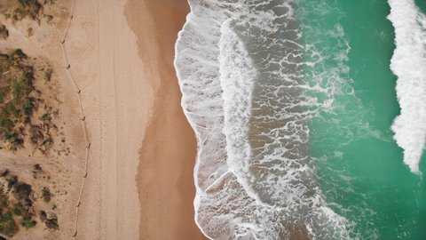 4K Aerial view top down of Beautiful beach with white sand and foaming waves crushing against coast line. Saler Beach, Valencia, Spain