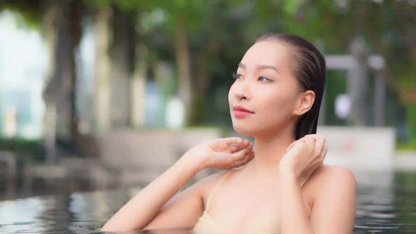 Nothing feels better then bushing back your wet hair when in a private resort pool. Narrow depth of field. | Shutterstock HD Video #1060532236