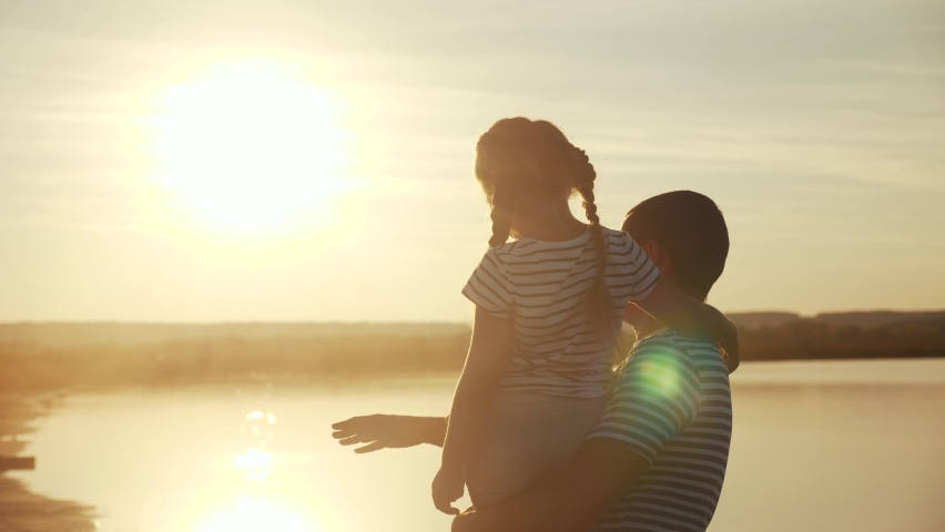 happy family. dad and daughter by the sea at sunset silhouette. father and child kid reach out to the sun. kid dream concept. happy family little girl and dad alone with nature relax sunset concept Royalty-Free Stock Footage #1060541224