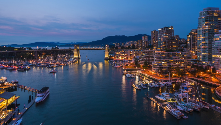 Vancouver, British Columbia, Canada, zoom out timelapse view of Downtown buildings and boats on False Creek at dusk.  Royalty-Free Stock Footage #1060542559