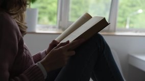 Woman reading book near window. Hand turns book pages. Self education concept - Powered by Shutterstock - Get 15% off with code: PIKWIZARD15