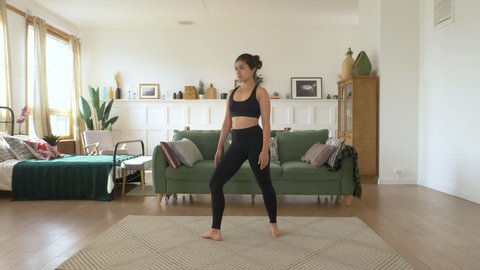 A young Indian Female Ballerina trains at home, Does a Spinning exercise, Bright Cozy Room, Dressed in a Black Top and Leggings. Sports Concept Healthy Life