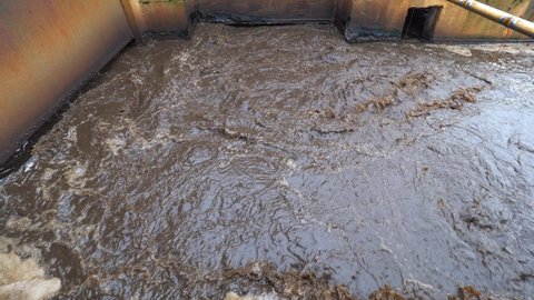 Thick sludge mixture in channel of wastewater treatment plant. Tanks for aeration and biological purification of sewage waste water. Activated sludge industrial wastewaters process.