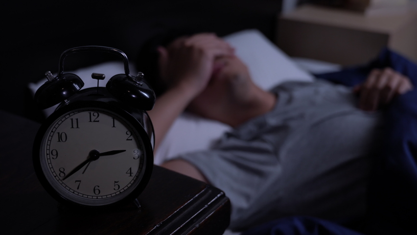 Depressed young Asian man cannot sleep from insomnia. Depressed man suffering from insomnia lying in bed. | Shutterstock HD Video #1060557775