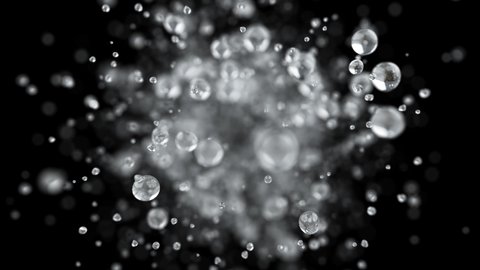 Explosion of water droplets into the camera in slow motion on an isolated black background.