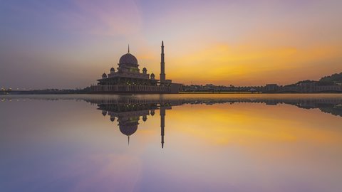 Beautiful golden sunset Time Lapse at Putra mosque by a lake in Putrajaya, Malaysia at dusk with reflection. Pan down motion timelapse. Prores Full HD