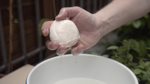 Soaked mozzarella cheese, squeezed by hand. slow motion