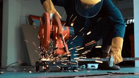 Professional mechanic is cutting steel metal with rotating diamond blade cutter. Steel industry and workshop concept. - Powered by Shutterstock - Get 15% off with code: PIKWIZARD15