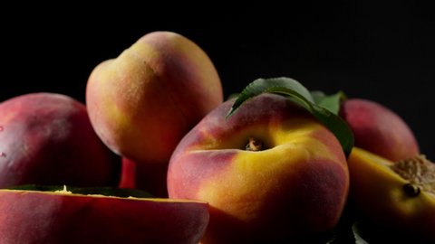 Rotating ripe peaches on dark background, closeup