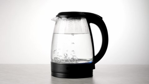 Man boiling water in an electric kettle on white background.
