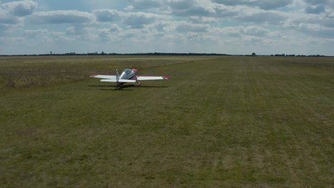 Small single-engine plane travels on a green field, makes a run before takeoff, summer, green grass, the concept of small aircraft. 
The plane takes off