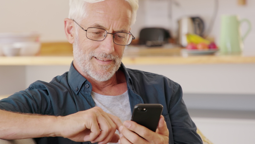 Man hands holding smartphone while order food delivery at home. Mature man using mobile app with smart phone to order lunch. Man sending email at home with cellphone. | Shutterstock HD Video #1060583623
