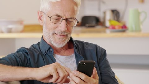 Man hands holding smartphone while order food delivery at home. Mature man using mobile app with smart phone to order lunch. Man sending email at home with cellphone.