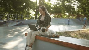 Dreadlocks girl sitting outdoors with her laptop computer and cute little pug is sitting near, she palms - Powered by Shutterstock - Get 15% off with code: PIKWIZARD15