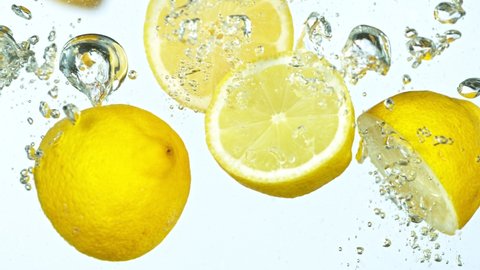 Super Slow Motion Shot of Fresh Lemons with Splashing Water Isolated on White Background. Filmed on high speed cinema camera.