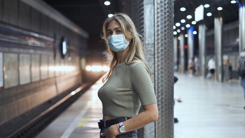 Passenger in mask stand metro station coronavirus. Woman looking at camera covid-19. Masked face woman waiting subway train for trip. View people in masks at underground station corona virus covid 19. Royalty-Free Stock Footage #1060596193