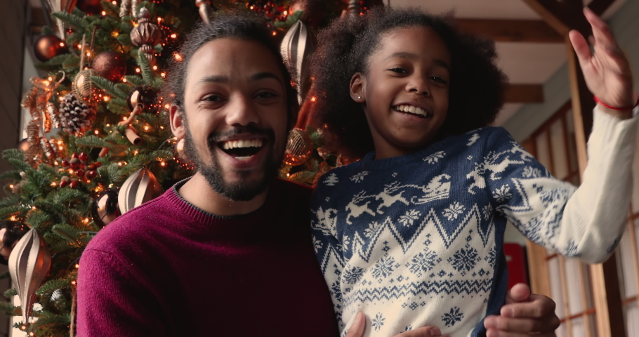 Happy african dad and kid girl start videoconference call talking greeting relatives congratulating 2021 and Merry Christmas. Best wishes, modern tech videocall application easy comfort usage concept Royalty-Free Stock Footage #1060600369