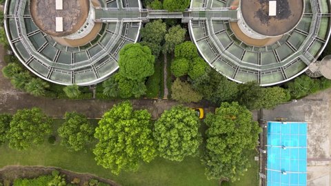 Drone aerial view of sewage water treatment plant with storage tanks and green trees. Ecology environmental conservation and industrial concept footage. Green plants around the tanks in Shanghai China