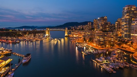 Vancouver, British Columbia, Canada, zoom in timelapse view of Downtown buildings and boats on False Creek at dusk. 